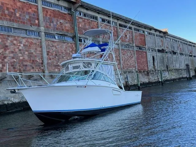 Slide: The Image of 2005 Albemarle 310 Express Fisherman boat docked near an industrial building. - 5