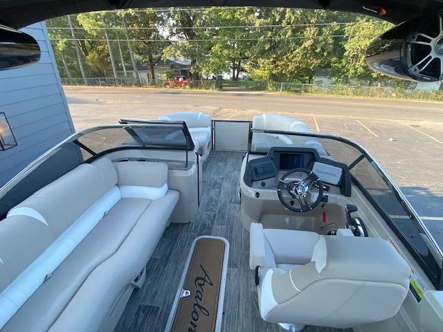 Slide: The Image of 2024 Avalon Catalina 2585 VRB pontoon boat interior with beige seating and modern dashboard. - 14