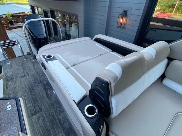 Slide: The Image of 2024 Avalon Catalina 2585 VRB boat interior with beige seating and cup holders. - 15