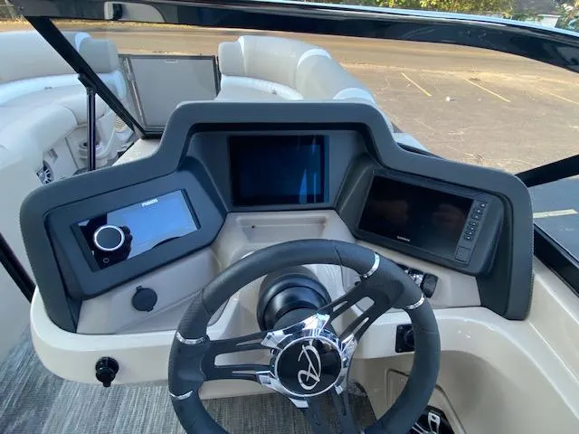 Slide: The Image of 2024 Avalon Catalina 2585 VRB boat dashboard with modern controls and steering wheel. - 17