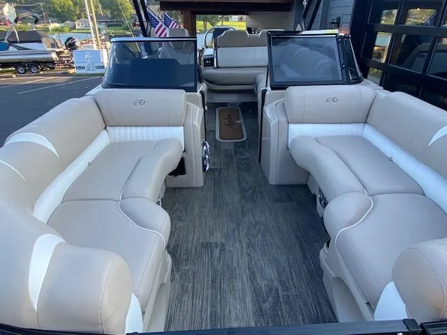 Slide: The Image of 2024 Avalon Catalina 2585 VRB boat interior with beige seating and wood flooring. - 18