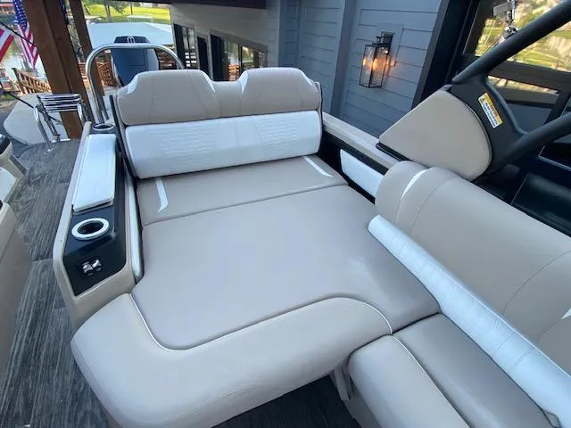 Slide: The Image of 2024 Avalon Catalina 2585 VRB boat interior with beige seating and cup holders. - 7