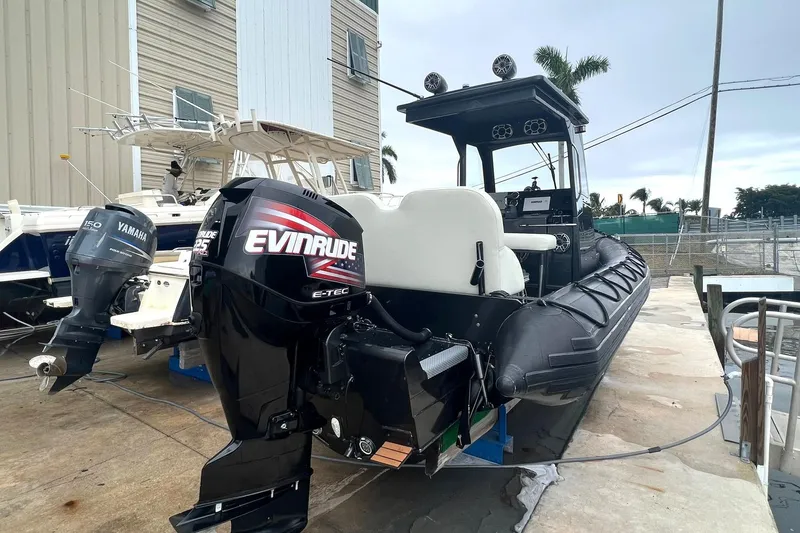 Slide: The Image of 2014 Zodiac Milpro Hurricane Custom boat with Evinrude outboard motor docked. - 3