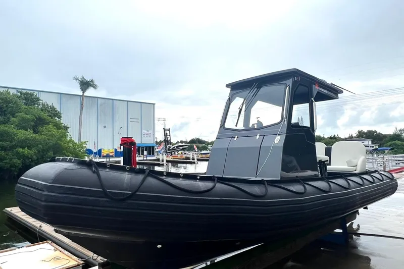 Slide: The Image of 2014 Zodiac Milpro Hurricane Custom boat docked at a marina. - 2