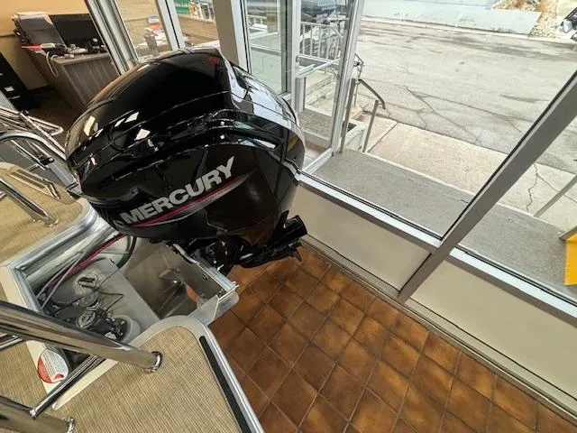 Slide: The Image of 2024 Harris Cruiser 210 CS with Mercury outboard motor in showroom. - 11