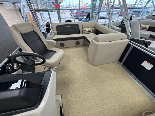 Slide: The Image of 2024 Harris Cruiser 210 CS pontoon boat interior with beige seating and steering console. - 5