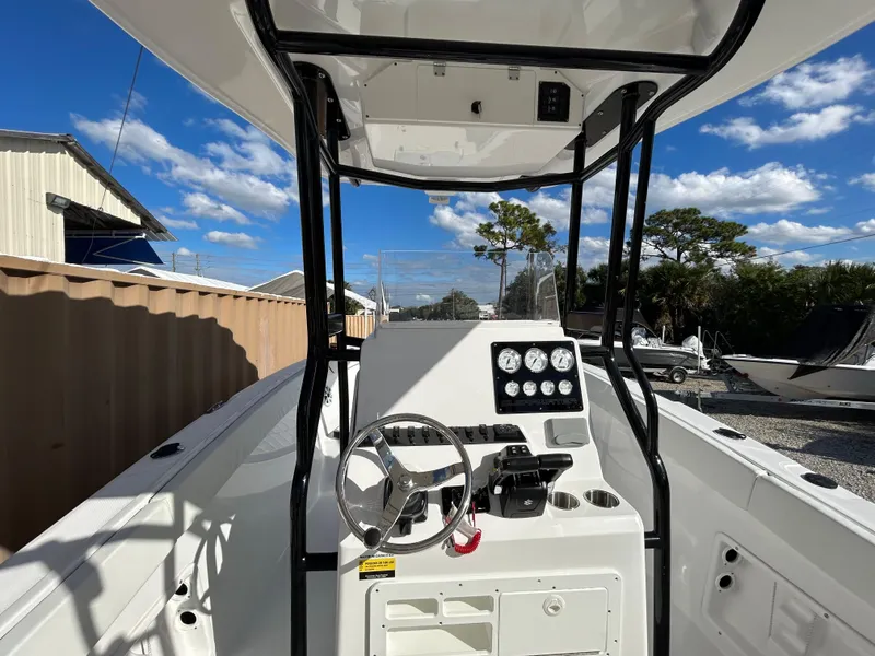 Slide: The Image of 2022 Clearwater 2300 boat dashboard with steering wheel and gauges. - 18