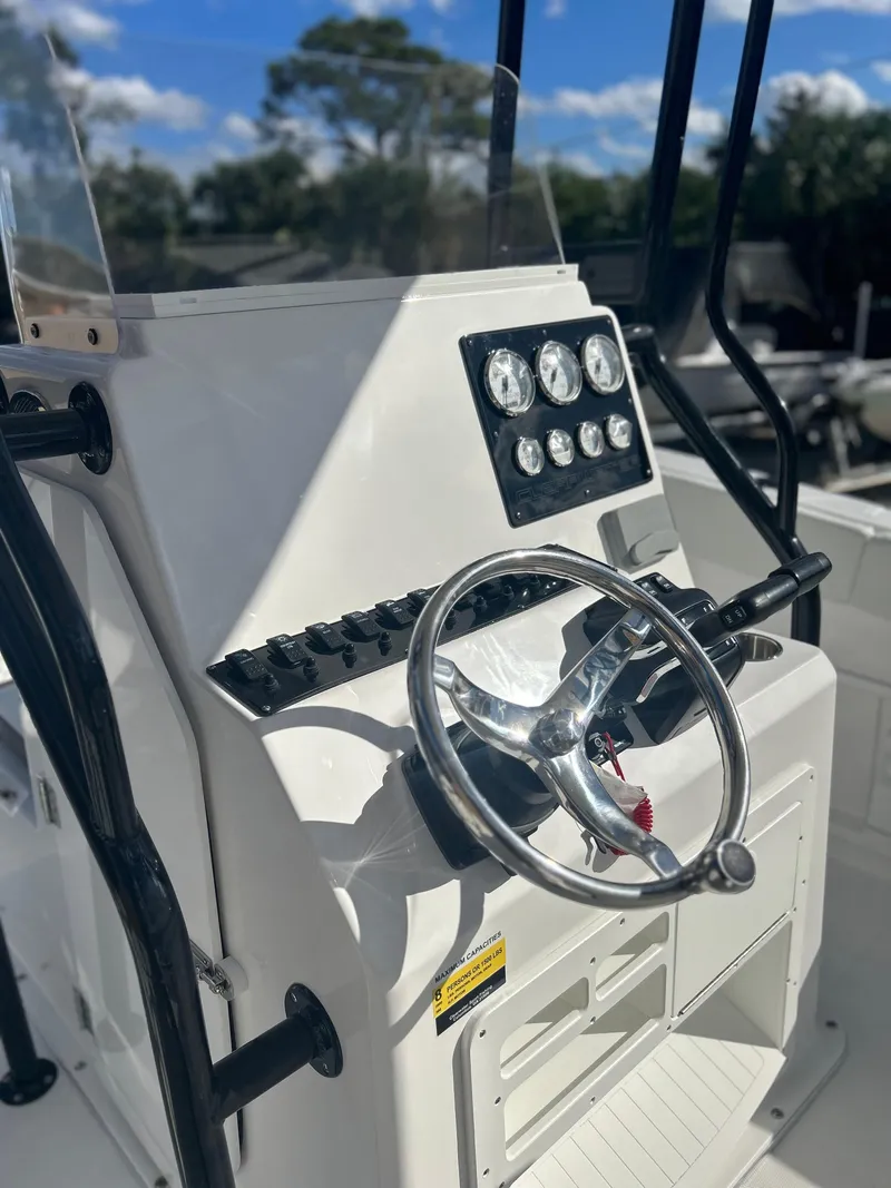 Slide: The Image of 2022 Clearwater 2300 boat console with steering wheel and instrument panel. - 19