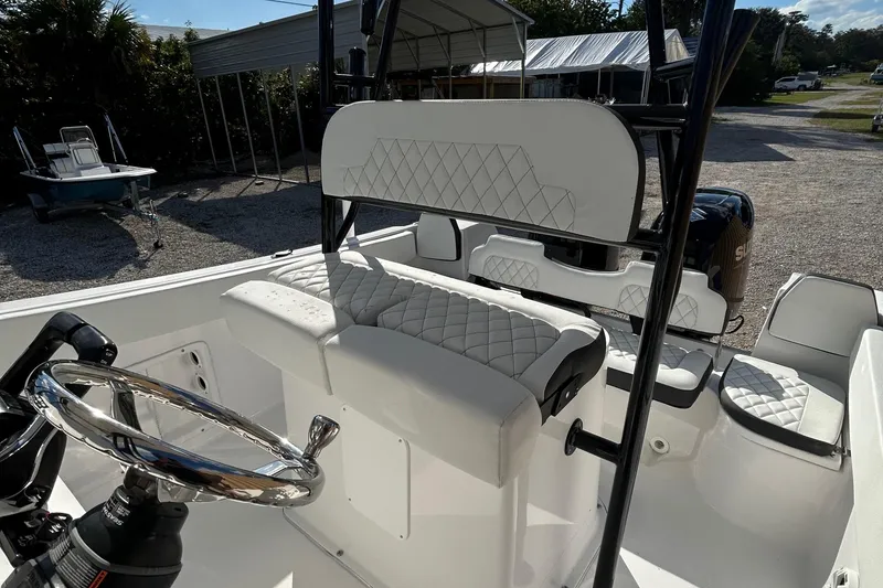 Slide: The Image of 2022 Clearwater 2300 boat interior with white quilted seats and steering wheel. - 24