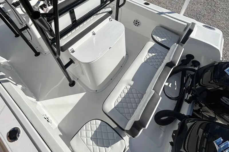 Slide: The Image of 2022 Clearwater 2300 boat interior with white cushioned seating and dual outboard motors. - 31