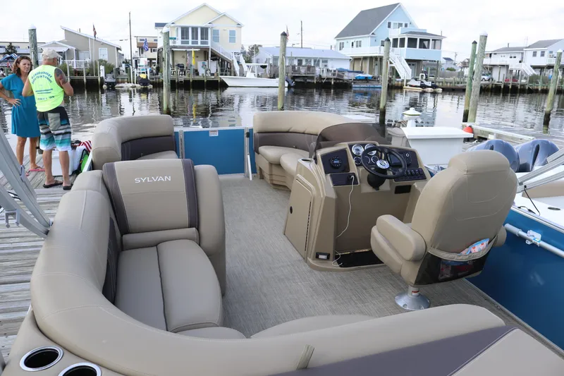 Slide: The Image of 2024 Sylvan Mirage 8520 Cruise pontoon boat with luxurious seating at a marina dock. - 14