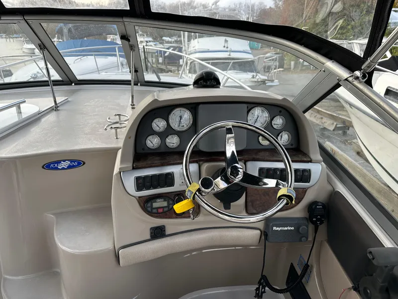 Slide: The Image of 2007 Four Winns 258 Vista boat helm with steering wheel, gauges, and Raymarine equipment. - 15