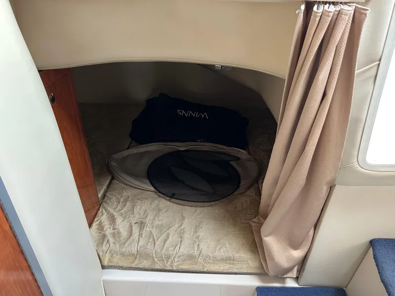 Slide: The Image of 2007 Four Winns 258 Vista cabin interior with bed and curtain. - 22