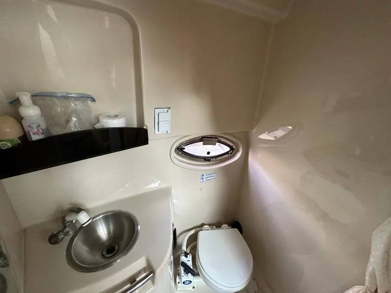 Slide: The Image of 2007 Four Winns 258 Vista boat bathroom with sink, toilet, and porthole window. - 24