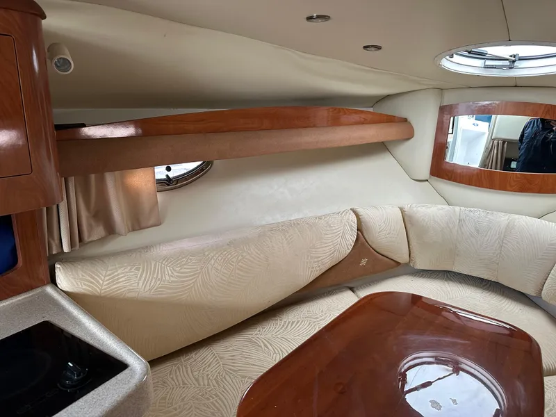 Slide: The Image of Interior of 2007 Four Winns 258 Vista boat with beige seating and wooden accents. - 30