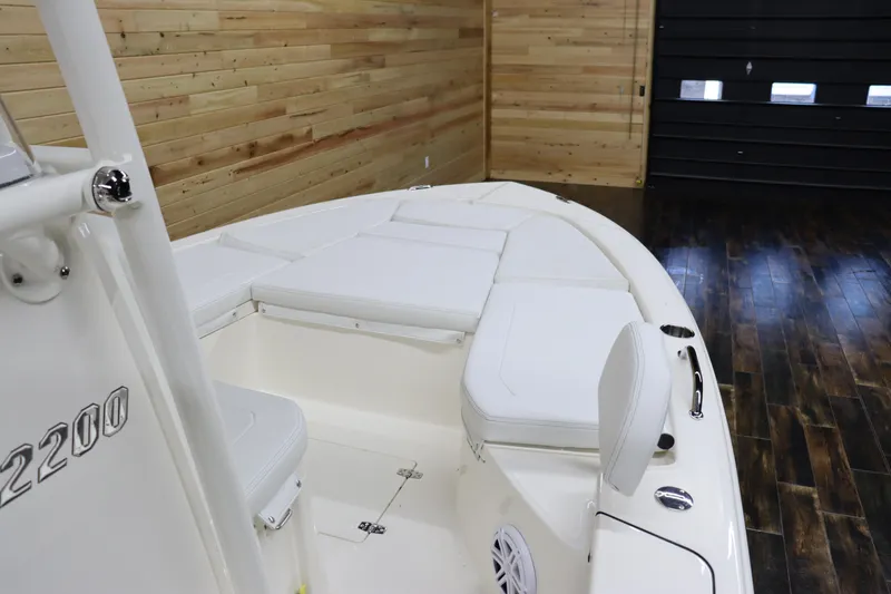 Slide: The Image of 2024 Pathfinder 2200 TRS boat interior with cushioned seating and wooden walls. - 24