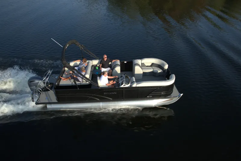 Slide: The Image of 2024 Sylvan Mirage 8522 CLZ pontoon boat cruising on a calm lake. - 11