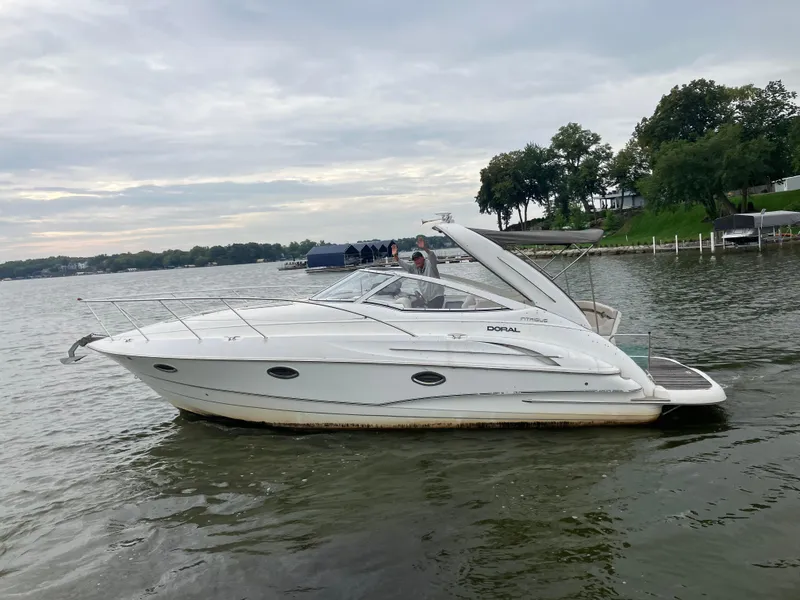 The Image of 2004 Doral Intrique boat on a calm lake with trees in the background. - 0
