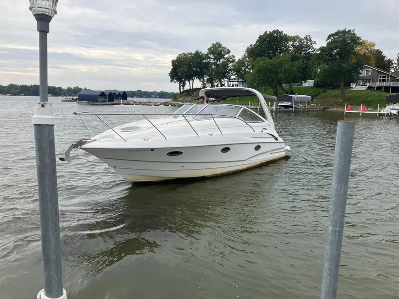 Slide: The Image of 2004 Doral Intrique boat docked on a calm lake with trees in the background. - 1