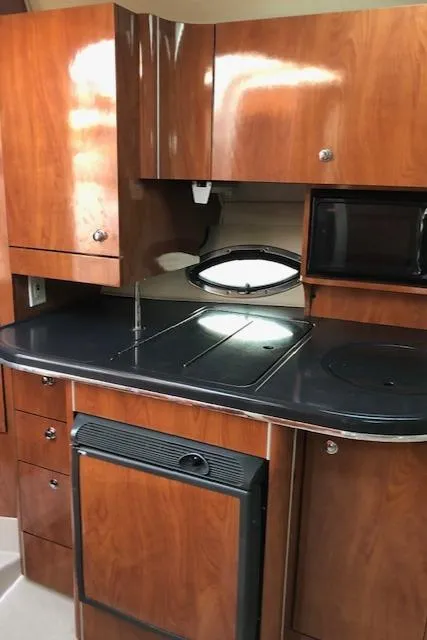 Slide: The Image of 2004 Doral Intrigue boat kitchen with wooden cabinets and black countertops. - 12