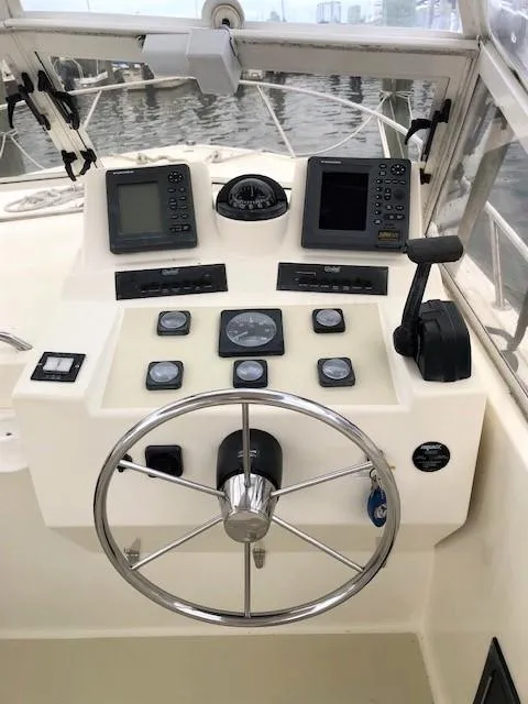 Slide: The Image of Helm of 2003 Carolina Classic 25 I/O boat with navigation instruments and steering wheel. - 10