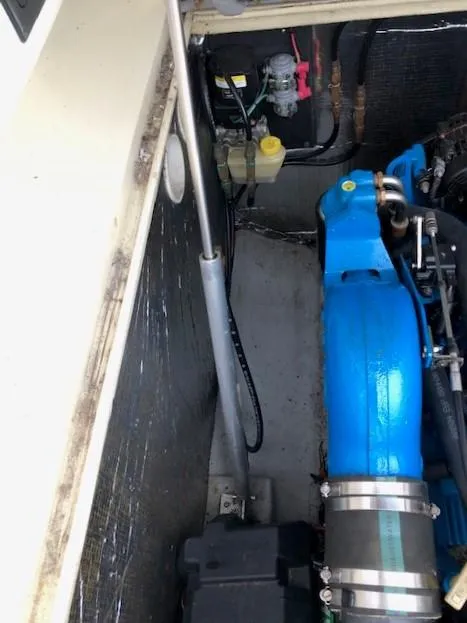 Slide: The Image of Engine compartment of a 2003 Carolina Classic 25 I/O boat, featuring blue engine components. - 18