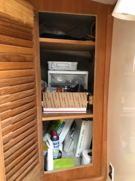 Slide: The Image of Wooden cabinet with assorted items inside a 2003 Carolina Classic 25 I/O boat. - 26