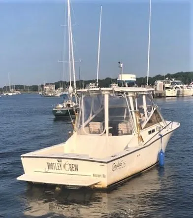 Slide: The Image of 2003 Carolina Classic 25 I/O boat docked in a marina, clear skies, calm waters. - 3