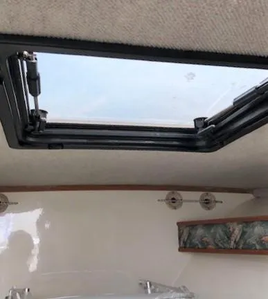 Slide: The Image of 2003 Carolina Classic 25 I/O cabin interior with open skylight and decorative shelf. - 32