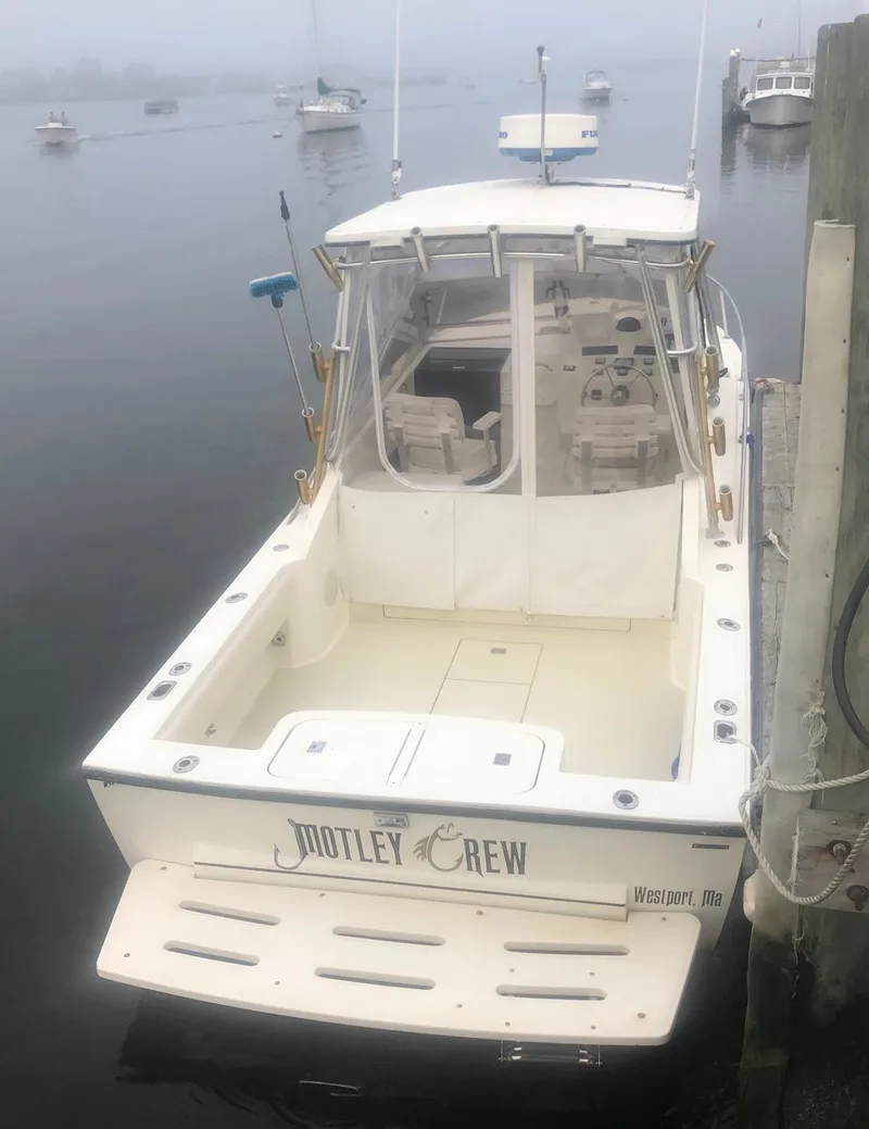 Slide: The Image of 2003 Carolina Classic 25 I/O boat docked in misty harbor. - 5