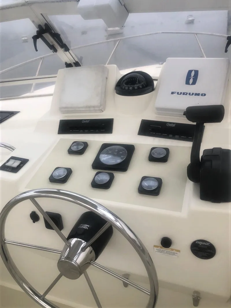 Slide: The Image of 2003 Carolina Classic 25 I/O boat dashboard with steering wheel and navigation instruments. - 6