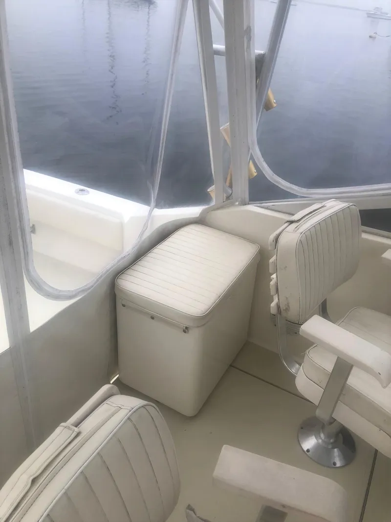 Slide: The Image of 2003 Carolina Classic 25 I/O boat interior with seating and storage, on calm water. - 8