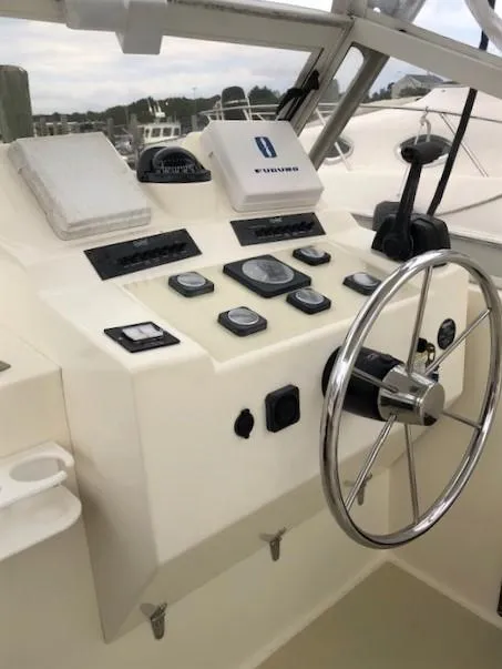 Slide: The Image of 2003 Carolina Classic 25 I/O boat dashboard with steering wheel and control panel. - 9