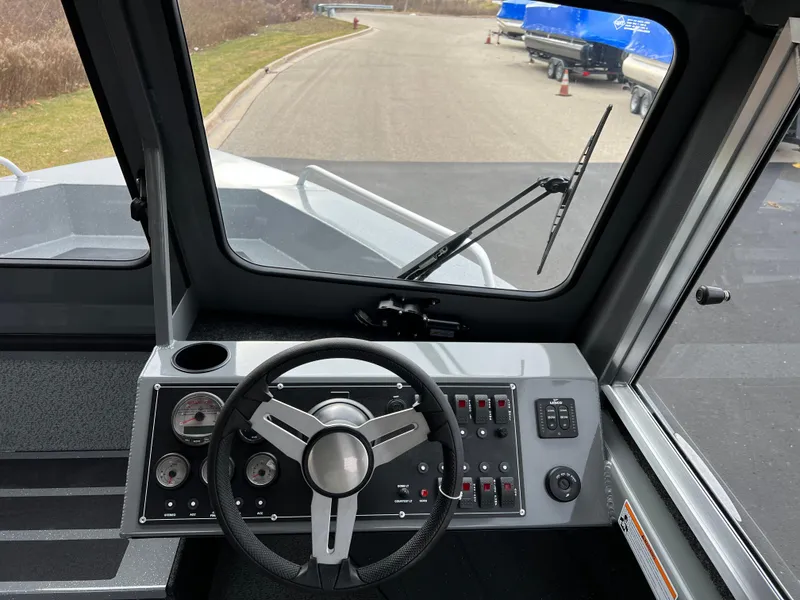 Slide: The Image of 2024 Spartan 215 Athens boat dashboard with steering wheel and control panel. - 8