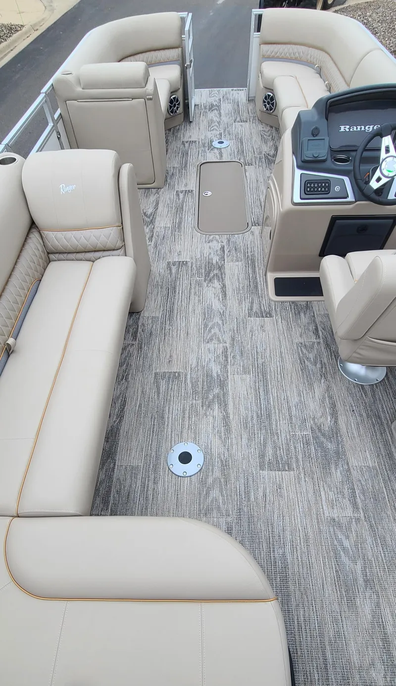 Slide: The Image of 2024 Ranger Reata 223C boat interior with beige seating and modern dashboard. - 7