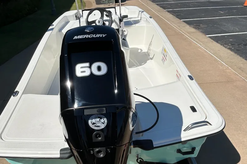 Slide: The Image of 2024 Mako Pro Skiff 15 CC with Mercury 60 engine, parked on pavement. - 4