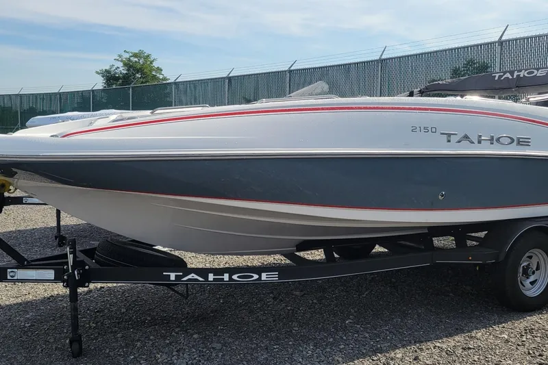 The Image of 2024 Tahoe 2150 boat on trailer, sleek design, parked outdoors. - 0