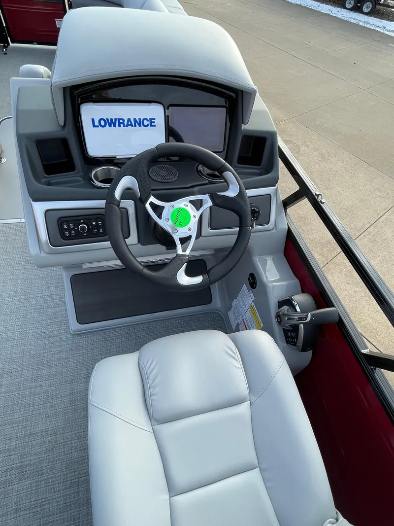 Slide: The Image of 2024 Regency 250 DL3 boat dashboard with Lowrance navigation system and steering wheel. - 4
