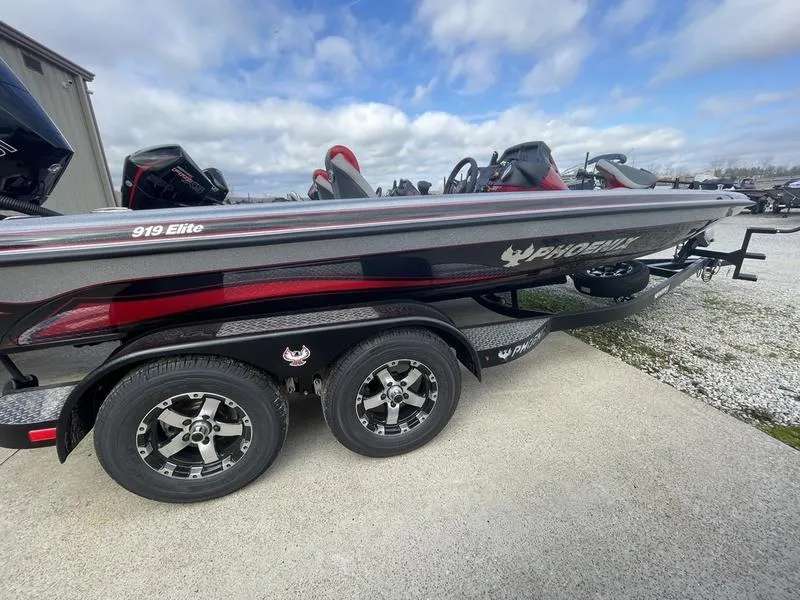 Slide: The Image of 2024 Phoenix 919 Elite boat on a trailer, side view with cloudy sky background. - 1