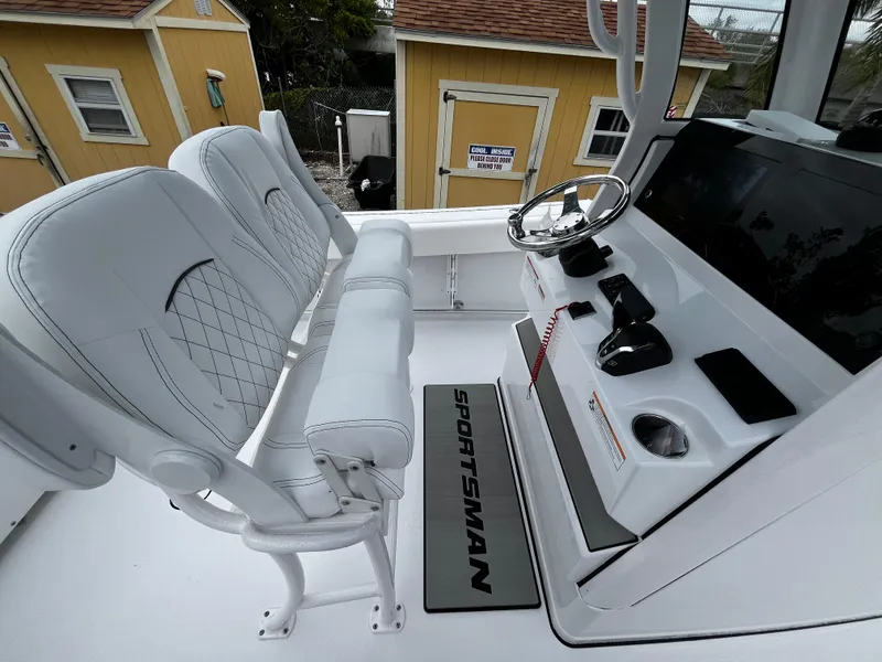 Slide: The Image of 2024 Sportsman Open 232 Center Console boat interior with white seating and control panel. - 10