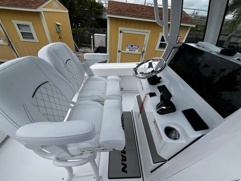 Slide: The Image of 2024 Sportsman Open 232 Center Console boat interior with white seating and control panel. - 11