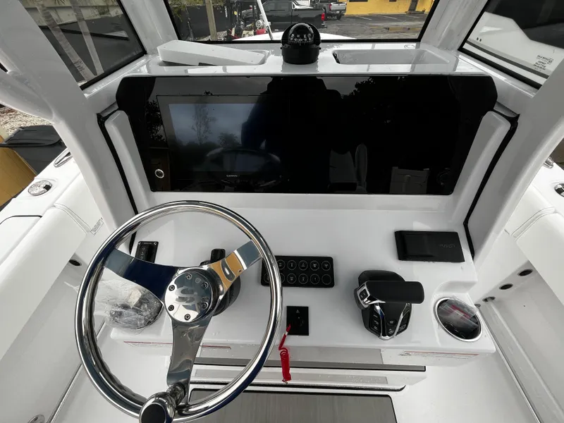 Slide: The Image of 2024 Sportsman Open 232 Center Console helm with steering wheel and control panel. - 14