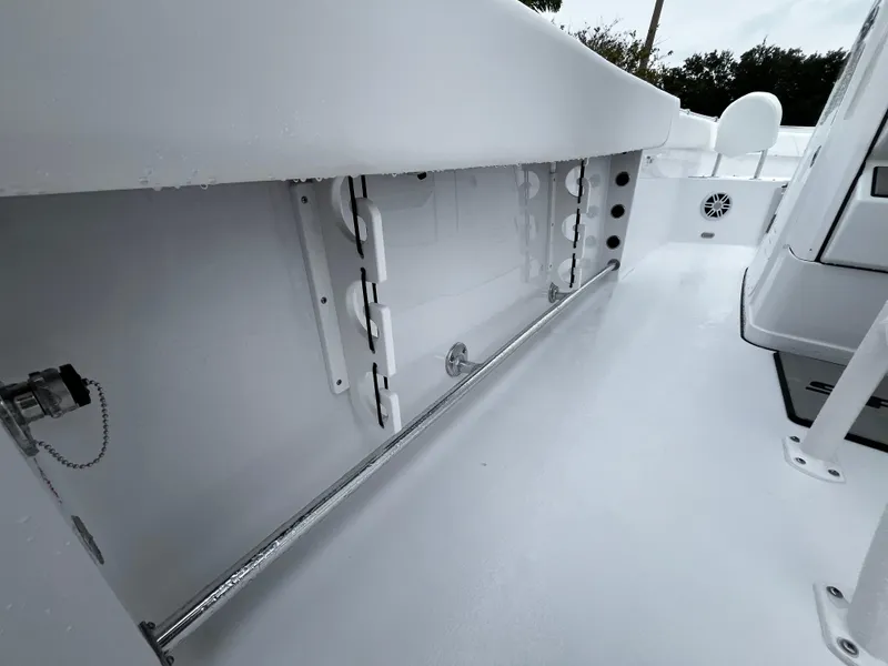 Slide: The Image of 2024 Sportsman Open 232 Center Console boat interior, featuring storage compartments and clean white finish. - 17