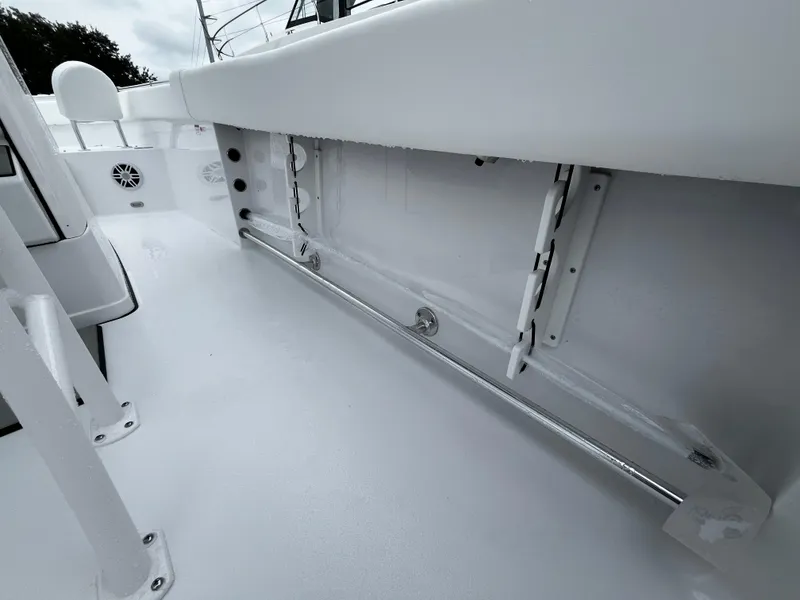 Slide: The Image of 2024 Sportsman Open 232 Center Console boat interior, featuring storage compartments and rod holders. - 18