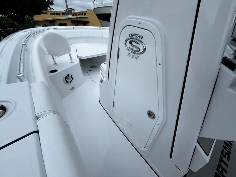 Slide: The Image of 2024 Sportsman Open 232 Center Console boat interior, white seating and storage compartments. - 19