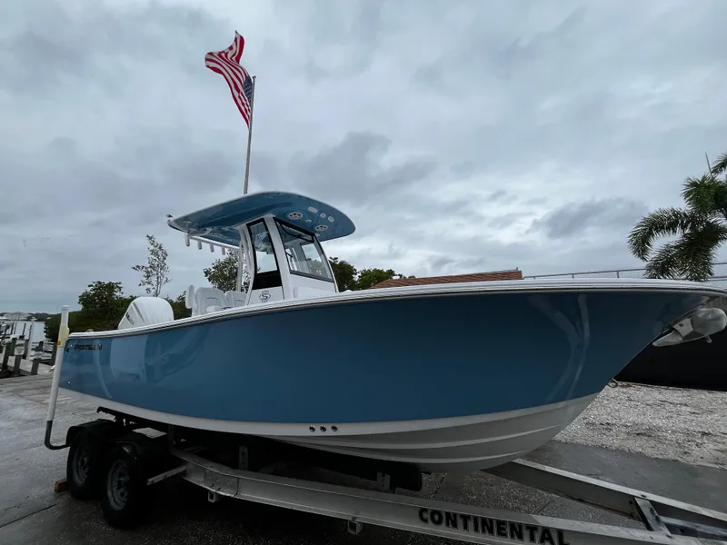 Slide: The Image of 2024 Sportsman Open 232 Center Console boat on trailer with American flag. - 2