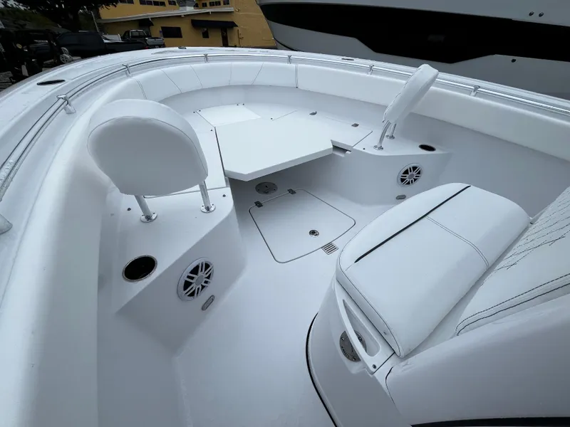 Slide: The Image of 2024 Sportsman Open 232 Center Console boat interior with white seating and table. - 21