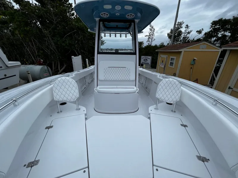 Slide: The Image of 2024 Sportsman Open 232 Center Console boat with white seating and storage compartments. - 22