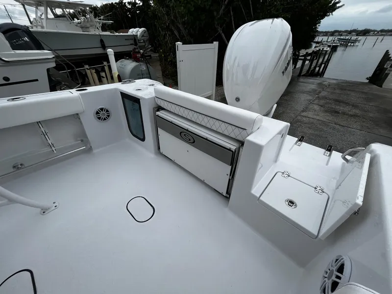 Slide: The Image of 2024 Sportsman Open 232 Center Console boat interior, docked near other boats. - 5