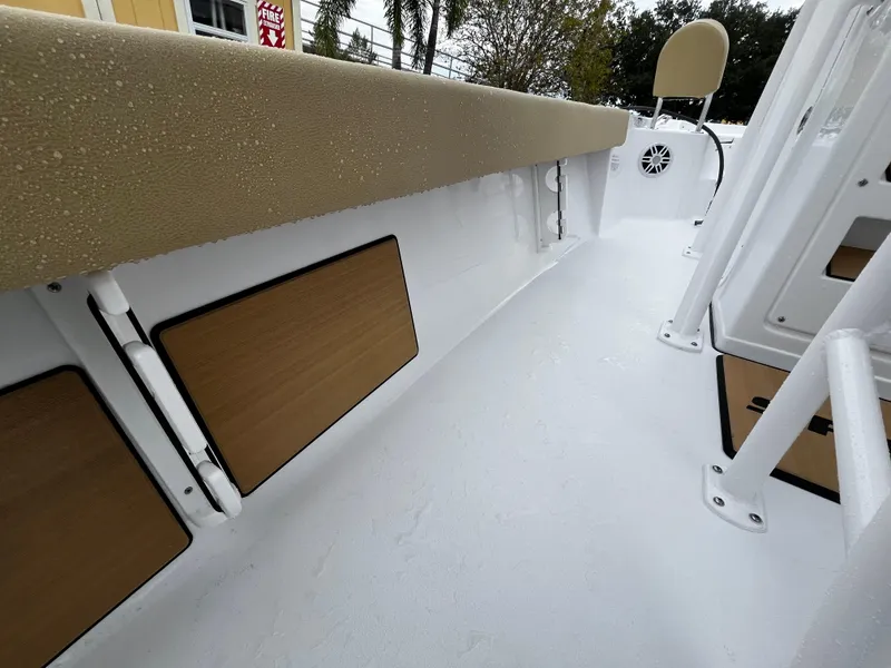 Slide: The Image of 2024 Sportsman Masters 227 Bay Boat interior with cushioned seating and storage compartments. - 17